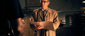 Robson Green as DI Geordie Keating in his brown overcoat holding a folder