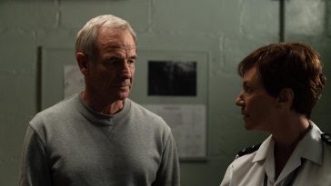 Patrick in prison looking at a female prison officer