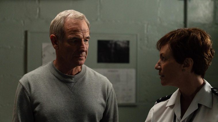 Patrick in prison looking at a female prison officer